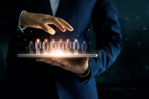 Businessman holding tablet and management group of people in his hand. Virtual icon of social network. Business technology concept.