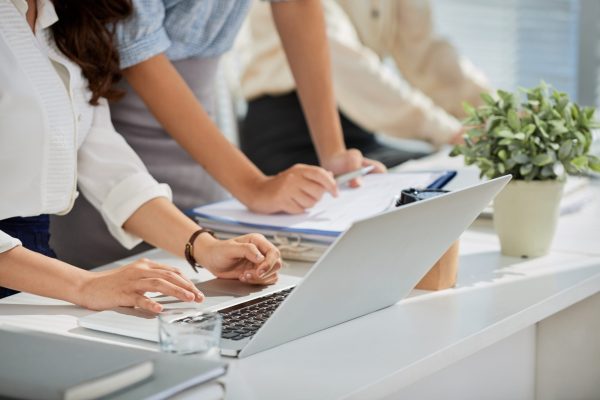 Cropped image of business ladies reading e-mails on laptop screen
