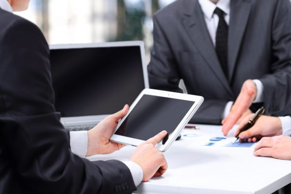Close-up of a modern business team using tablet computer to work
