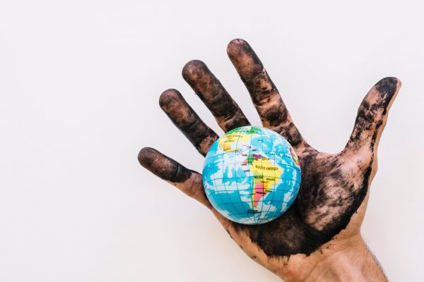 close-up-of-dirty-human-hand-with-globe-over-white-surface