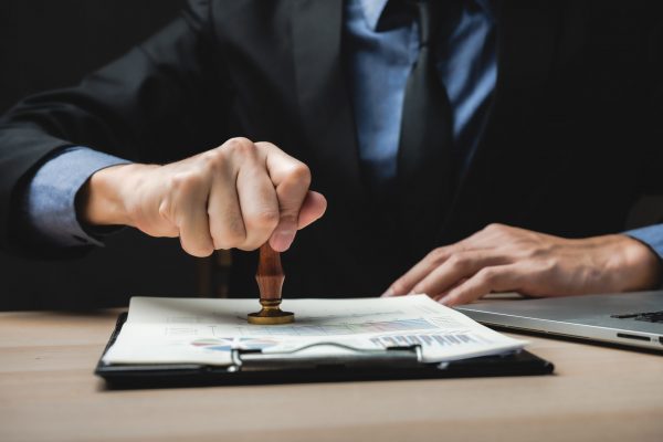 Sign Approved Stamp On Document to permit and certify for work document and visa At Desk